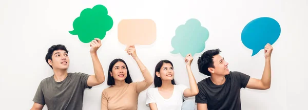 Group of friends holding a speech bubble icon — Stock Photo, Image