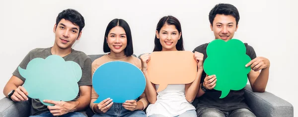 Grupp vänner som håller en pratbubbla ikon — Stockfoto