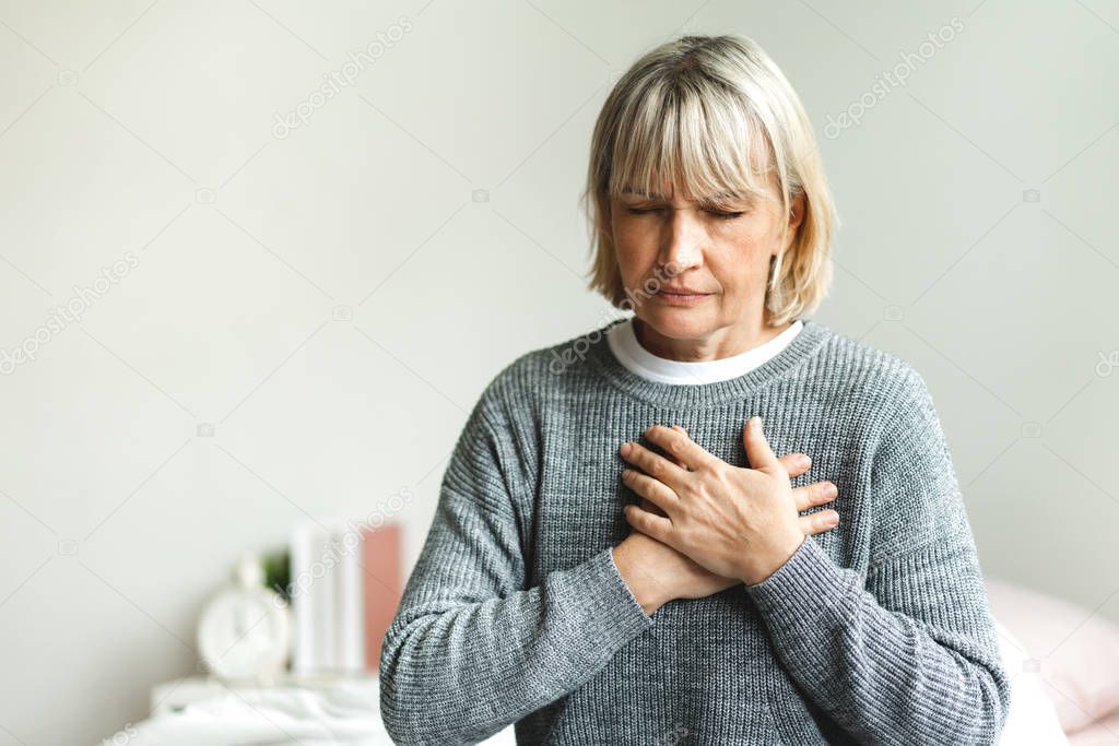 Senior adult elderly women sit on bed with chest pain suffering 