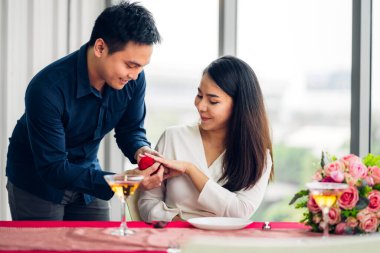 Genç yakışıklı bir adam kız arkadaşına sürpriz yapmak için yüzük veriyor.