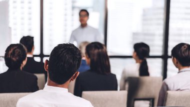 Salon veya seminer odasındaki danışmanlık konferansı seminerinde bir grup insanın önünde duran iş adamı. Sunum ve koçluk konsepti