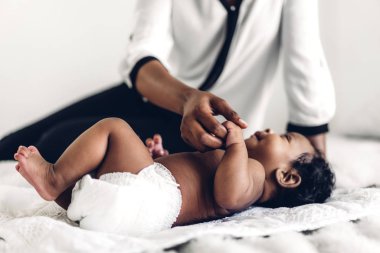 Afrika kökenli Amerikalı anne, beyaz bir odada sevimli, küçük bir Afrikalı Amerikalı bebekle oynuyor. Siyahi aile kavramına bayılıyorum.