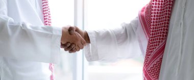 Arap iş ortağının modern ofiste el sıkışması başarılı oldu. Ortaklık onayı ve jest konseptine teşekkürler