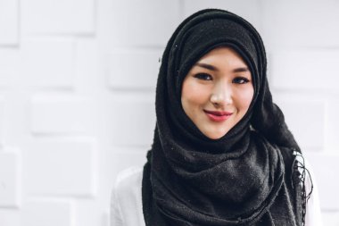 tesettürlü mutlu Müslüman kadın portresi gülümsüyor ve beyaz arka plandaki kameraya bakın.