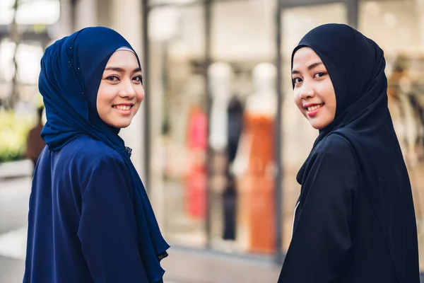 Portrait of happy arabic two friend muslim woman with hijab dress smiling and look at camera at store