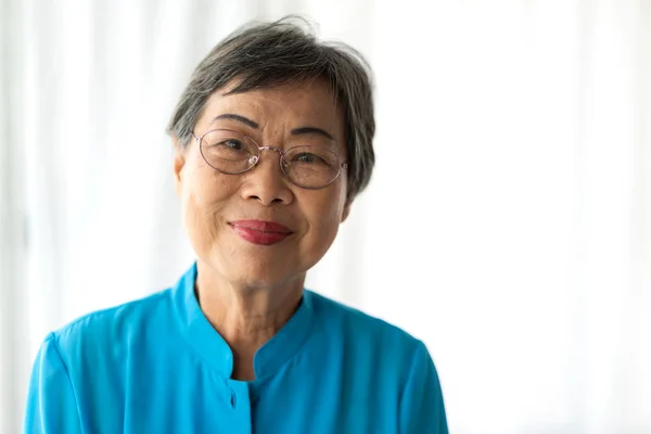 亚洲老年快乐女性的画像 微笑着看着家里的相机 退休的概念 — 图库照片