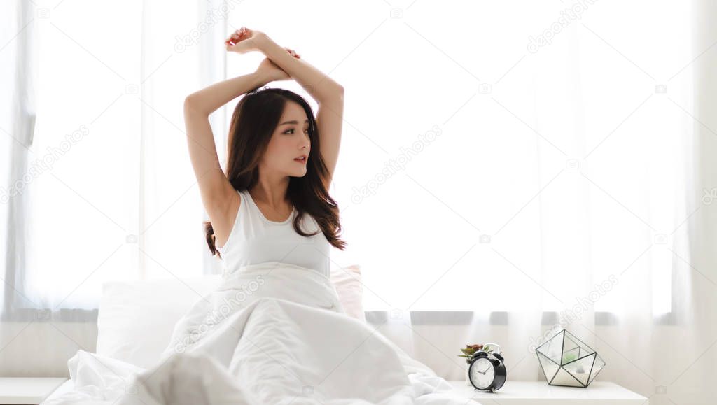 Woman stretching after wake up and she feeling happy and relaxed breathing fresh air at morning