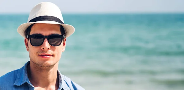 穿着时髦太阳镜 戴着时髦夏草帽 站在热带海滩上欣赏友情的快乐帅气男人的画像 暑假和旅行 — 图库照片
