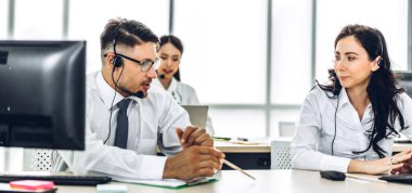 Mutlu çağrı merkezi gülümseme operatörü müşteri desteği danışma ekibi telefon hizmetleri çağrı merkezindeki masaüstü bilgisayarında çalışan ve kablosuz mikrofon ile konuşan