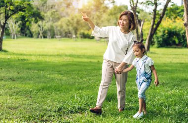 Mutlu bir aşk portresi. Asyalı aile babaannesi ve küçük tatlı kız çocuğu. Eğleniyorlar.