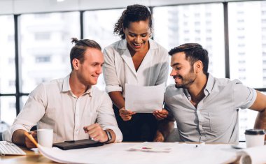 Profesyonel iş toplantıları ve yeni başlangıç projesiyle strateji tartışmaları. Yaratıcı iş adamları modern çalışma ortamında belge raporlarıyla plan yapıyor ve beyin fırtınası yapıyorlar. Takım çalışması kavramı.