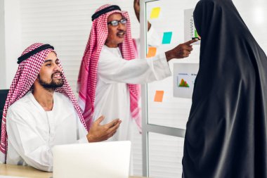 Üniversiteli Arap iş adamlarının dizüstü bilgisayar ve belge raporlarıyla çalışmalarının başarısı. Yaratıcı Arap iş adamları yeni bir başlangıç projesi projesiyle buluşup strateji analizi planlıyorlar.