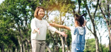 Mutlu büyükanne ve küçük sevimli kız Portresi yaz parkı birlikte dinlenmek keyfini çıkarın, küçük kız büyükanne ve sarılmak için çalıştırın. Aile ve birliktelik