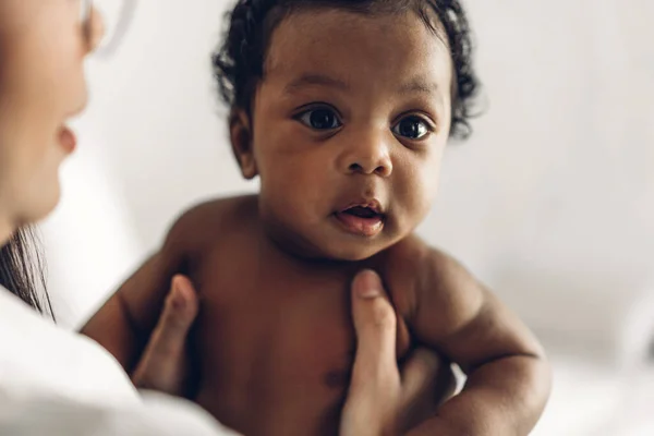 幸せな愛の家族の肖像画アフリカ系アメリカ人の母親は愛らしい小さなアフリカ系アメリカ人の赤ちゃんと遊んでいます お母さんは白い寝室で楽しい時間をかわいい息子の瞬間に触れて ブラック家族の概念の愛 — ストック写真