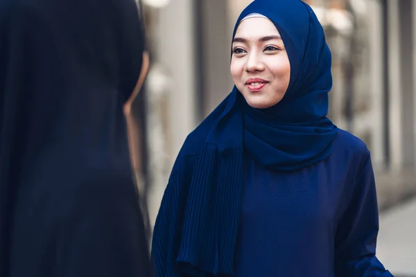 Portrait of happy arabic two friend muslim woman with hijab dress smiling and talking together at store