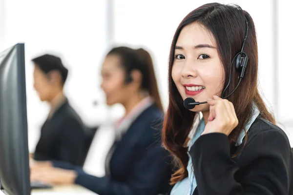 Beautiful happy call center smiling asian businesswoman operator customer support phone services agen working with headset and computer at call center