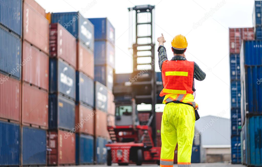 Professional engineer container cargo foreman in helmets working standing and checking stock into container for loading.logistic and business export
