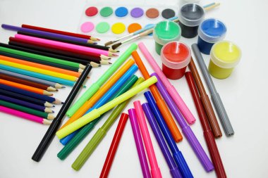 Renkli kalemler, işaretleri ve beyaz bir arka plan üzerinde boya