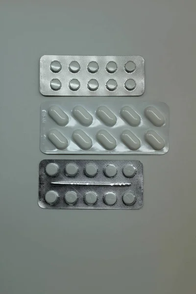 Tabletten in verschiedenen Formen auf dunkelgrauem Hintergrund — Stockfoto