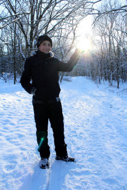 Kış orman içindeki çocuk güneş avucunda tutan.