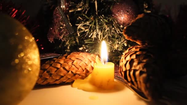 Brinnande ljus på en bakgrund av juldekorationer. — Stockvideo