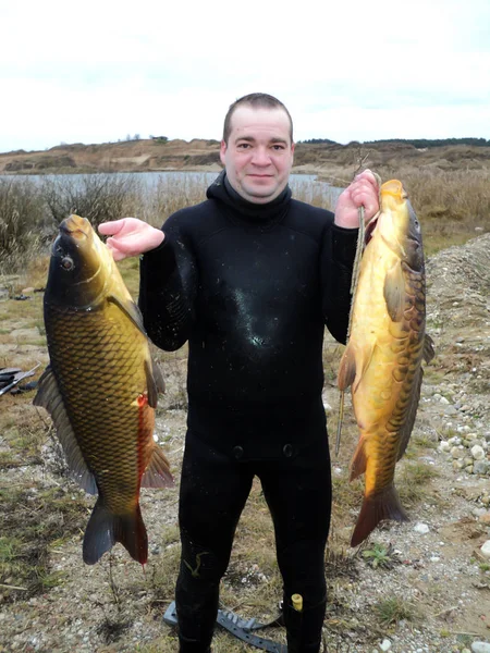 Pêche à la lance. Un homme en combinaison de plongée avec un gros poisson à la main . — Photo