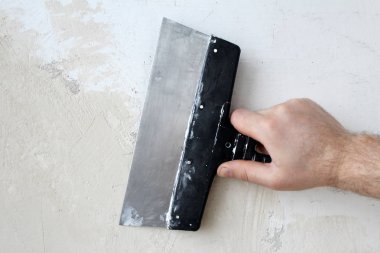 Spatula el. İç döşeme. Duvarları macunları.