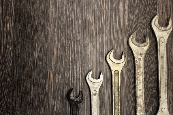 Metalen slagmoersleutels op houten achtergrond in retro stijl. — Stockfoto