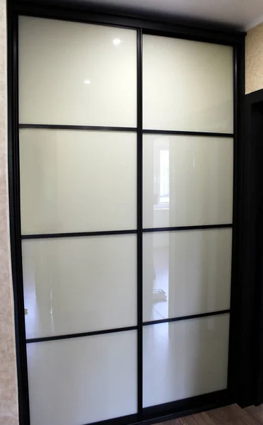 Коричневый шкаф с раздвижными дверями из белого стекла — стоковое фото