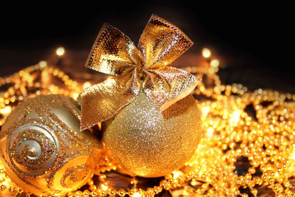Goldene Weihnachtskugeln auf schwarzem Hintergrund. — Stockfoto