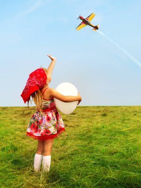 uçak uçan bir el sallayarak bir balon ile küçük kız.