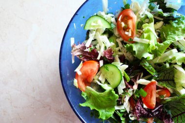 Mavi kasede taze sebzeler. Karıştır. Sebze ve bitki salatası.