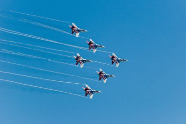 Altı savaş süpersonik avcı mig-29 mavi boyalı ve kırmızı renkler mavi gökyüzüne karşı bir takım çalışması için sıkı grup, birbirlerine, yakın uçuyor.