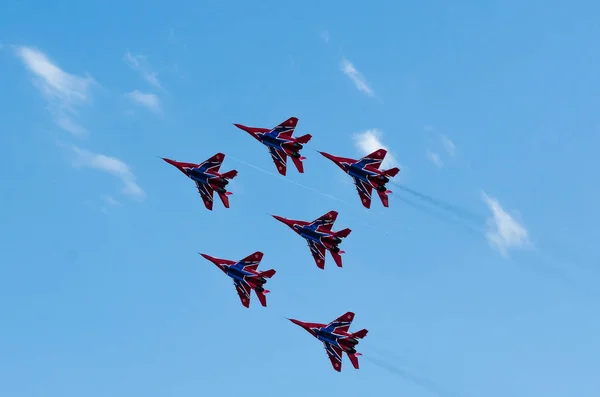 Saint petersburg, russland - 9. juli 2017: sechs in blau und rot lackierte Kampfflugzeuge Mig-29 fliegen in einer engen gruppe gegen den blauen himmel. — Stockfoto