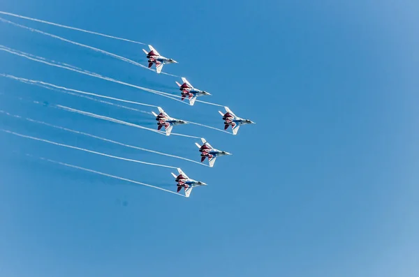 Saint petersburg, russland - 9. juli 2017: sechs in blau und rot lackierte Kampfflugzeuge Mig-29 fliegen in einer engen gruppe gegen den blauen himmel. — Stockfoto