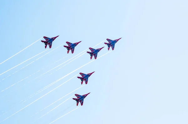 Saint petersburg, russland - 9. juli 2017: sechs in blau und rot lackierte Kampfflugzeuge Mig-29 fliegen in einer engen gruppe gegen den blauen himmel. — Stockfoto