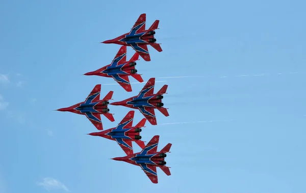 Sint-Petersburg, Rusland - 9 juli 2017: zes bestrijding supersonische vechter mig-29 geschilderd in blauw en rode kleuren zijn vliegen in een hechte groep, tegen de blauwe hemel. — Stockfoto