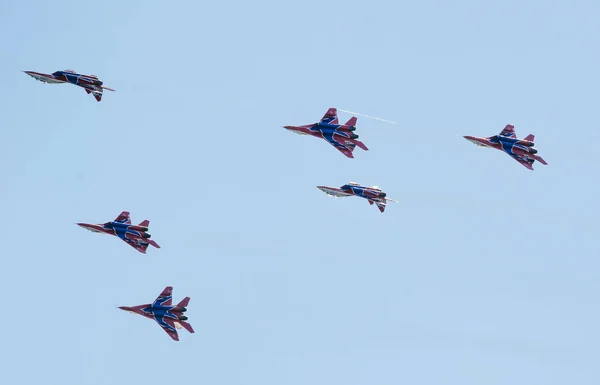 Saint petersburg, russland - 9. juli 2017: sechs in blau und rot lackierte Kampfflugzeuge Mig-29 fliegen in einer engen gruppe gegen den blauen himmel. — Stockfoto