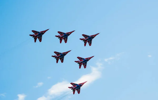 Saint petersburg, russland - 9. juli 2017: sechs in blau und rot lackierte Kampfflugzeuge Mig-29 fliegen in einer engen gruppe gegen den blauen himmel. — Stockfoto