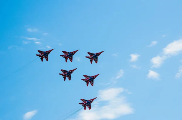 Saint petersburg, russland - 9. juli 2017: sechs in blau und rot lackierte Kampfflugzeuge Mig-29 fliegen in einer engen gruppe gegen den blauen himmel. — Stockfoto