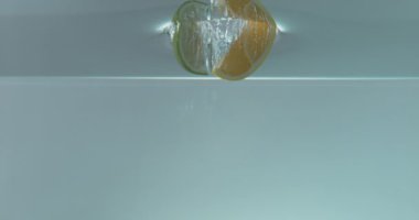 Limon dilimlerinin suya düşüşünün yavaş çekim görüntüleri.