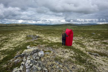 Kızıl hava şezlonguyla çöl manzarasını izleyen genç kadın. 
