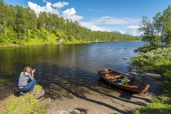 Genç kadın Norveç 'teki göl ve orman manzarasını fotoğraflıyor. — Stok fotoğraf