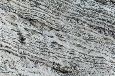 Layers of dark flint pebbles in limestone of Cretaceous age, in the Normandy, France. clipart