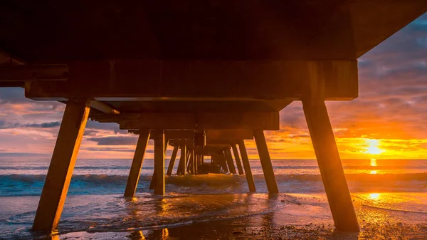 Vista dramática do pôr-do-sol de baixo do cais — Fotografia de Stock