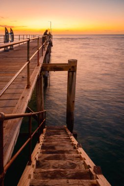 Port Noarlunga iskelesinde balık tutan insanlar