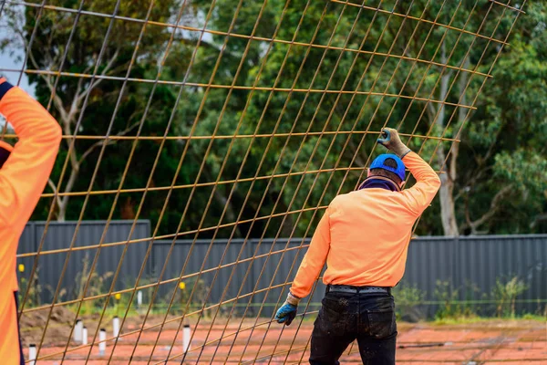 Australian builder carrying steel mesh — 스톡 사진