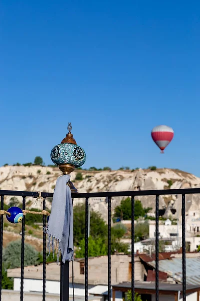 scarf tied to a turkish lamp on the balcony. on a blurred balloon background. cappadocia