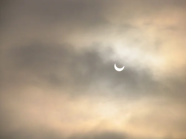 Sol coberto com nuvens durante o eclipse solar parcial — Fotografia de Stock