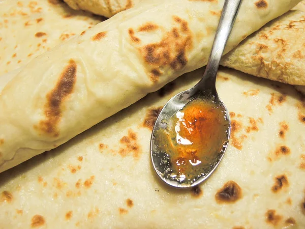 Leckere Crêpes gefüllt mit Marmelade und Teelöffel — Stockfoto